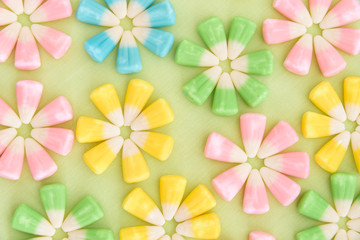 Close up of festive Easter candy corn in flower patterns on a light green background
