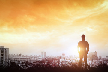 Obraz na płótnie Canvas Silhouette of businessman to city way light the sunset.