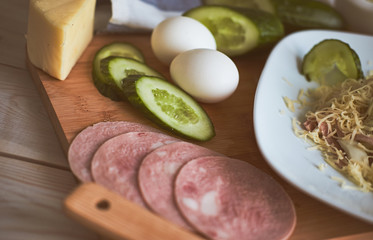 Ingredients for salad. Cucumber, egg, cheese, ham, gravy, towels