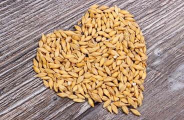 Heart of barley grain on wooden background