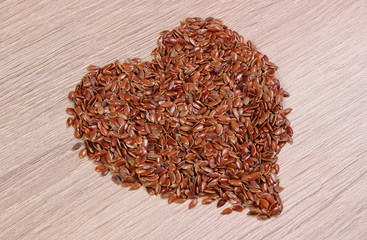 Heart of linseed on wooden background