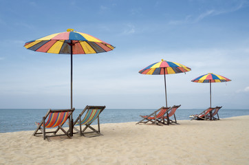 View of nice tropical empty sandy beach with umbrella and beach chair 