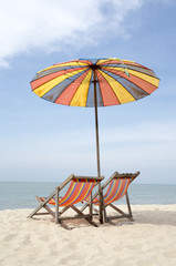 Two sun loungers and an umbrella on a sunny day