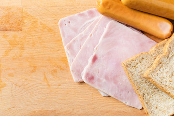 Ham,sausages  and bread on a wooden cutting board