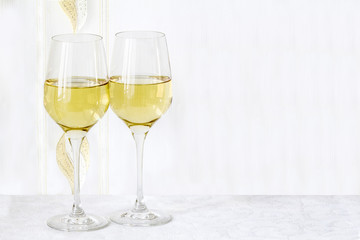 Two glass  wine are stand on the white tablecloth