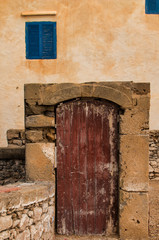 Fototapeta na wymiar Old gate and windows with blue shutters, Morocco