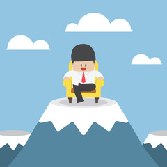 Successful businessman is sitting on sofa at mountain peak