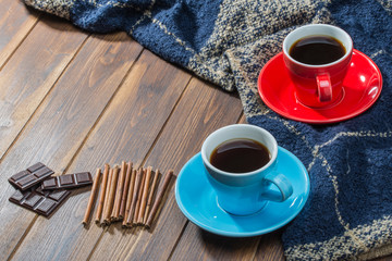 Blanket and two cups of coffee on wooden floor