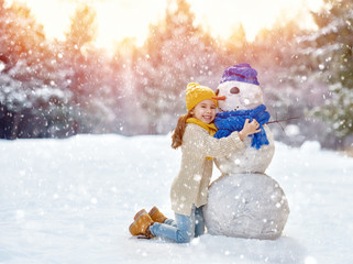 girl playing with a snowman