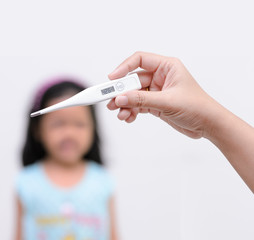 Hand holding digital thermometer for fever measurement with blur