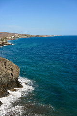 View down the cliffs of Gran Canaria on the wide atlantic ocean / green and blue water under great cliffs of gran canaria