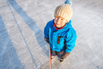 Winter time. Young boy playing ice hockey on an outdoor ice rink.  Overhead view