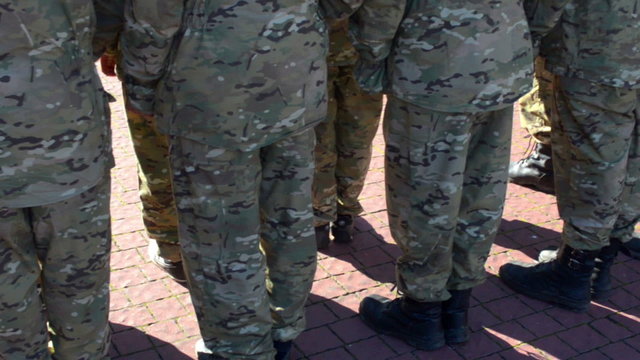 Men`s legs in the military camouflage uniform