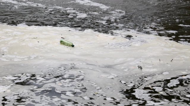 Plastic bottles floating in polluted river water. 
