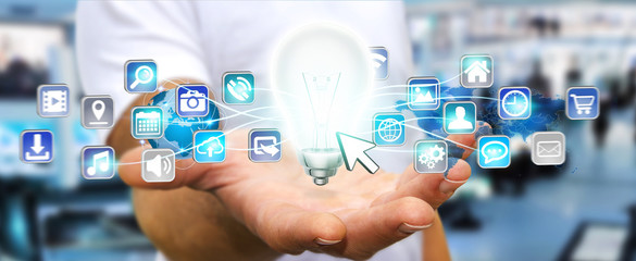 Businessman holding lightbulb with digital icons