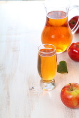Apple juice and apples on a  wooden table