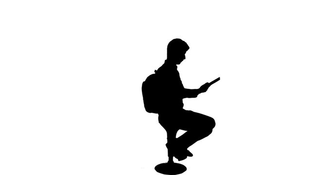 Silhouette of a student reading a book - 1080p. Silhouette of a sit down reading book studying for exams silhouette. Full HD
