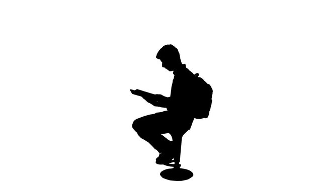 University student reading book silhouette - 1080p. Silhouette of a sit down reading book studying for exams silhouette. Full HD

