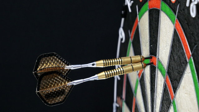 three darts hitting triple twenty on a dart board