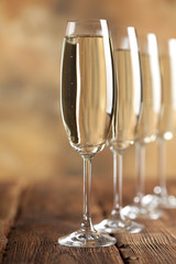 Glasses of champagne on brown background