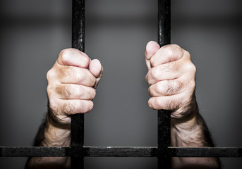 prisonnier/mains de prisonnier derrière les barreaux