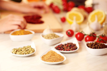 Variety of spices in ceramic containers on the kitchen table