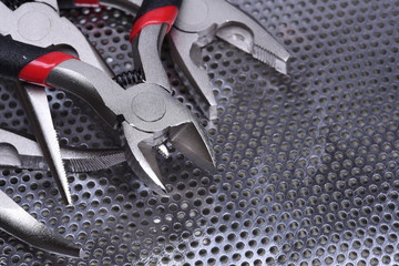 Electrical tools wire cutter, pliers on metal background