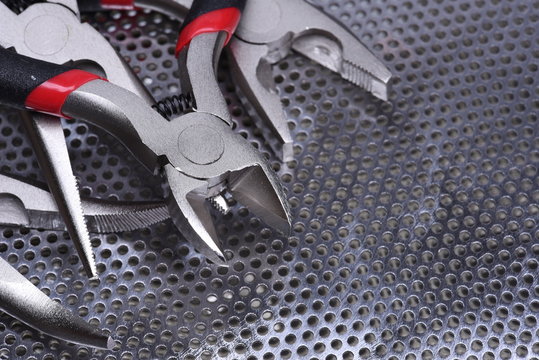 Electrical tools wire cutter, pliers on metal background