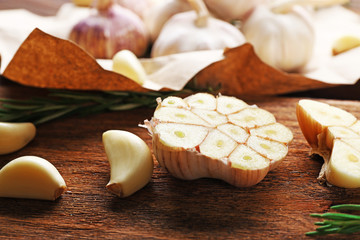 Composition of garlic and rosemary on the kitchen board, close up