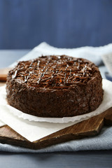 Tasty chocolate cake on color wooden background