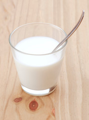 glass of milk with spoon and sugar cubes