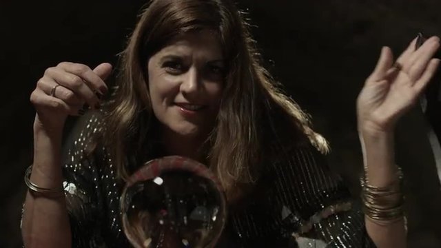Gypsy fortune teller reveals crystal ball and starts looking into it.  Close up. Ultra high definition, 4K.