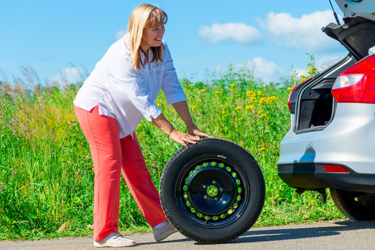 50-year-old woman have prepared to replace the spare wheel