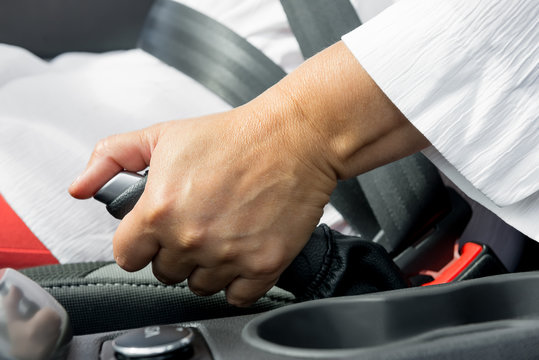 woman's hand and the hand brake of the car close-up