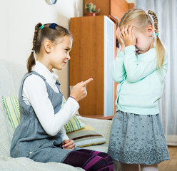 girl lecturing little sister in domestic interior