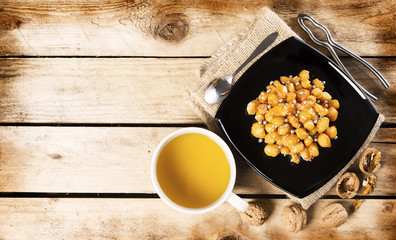 Wood table with struffoli and a cup of hot chamomile
