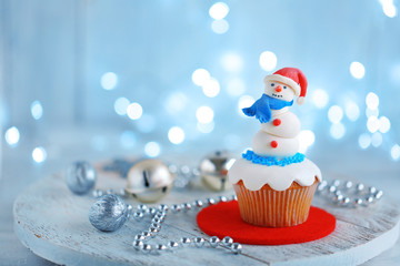 Christmas cupcake with lights on background