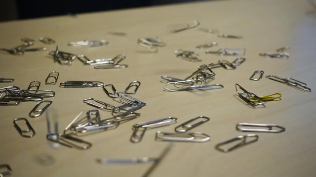 Des trombones tombant sur un bureau en slow motion