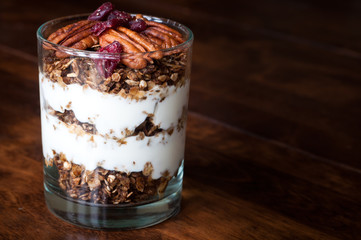 A healthy breakfast of gingerbread granola layered with greek yogurt and topped with pecan nuts.