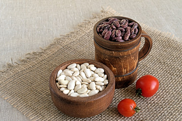 Beans.  Beans red and white in a wooden cookware on a background of burlap.
  