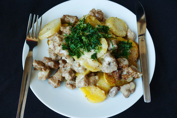 Baked potatoes, pork with cream view