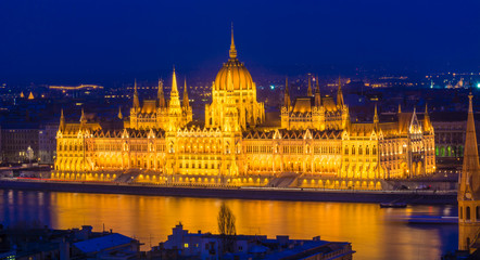 Fototapeta na wymiar Budapest Parliament building illuminated at dusk reflected in Danube river in Hungary