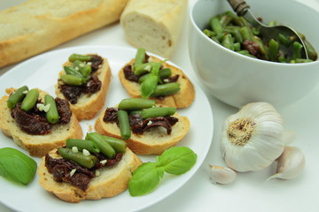 Bruschettas with sundried tomatos and green beans with garlic and basil. Vegetarian meal