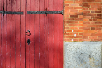 Old red wood gate on brick building