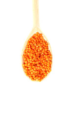 Red lentils in the wooden spoon on a white background