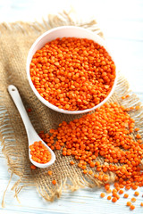 Red lentils in bowl on a blue wooden table