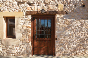 puerta de madera de una casa de piedra © uzkiland