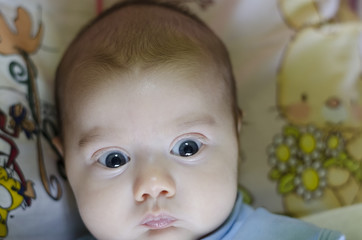 A cute little baby is looking into the camera