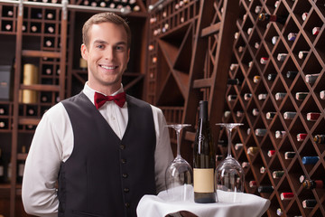 Attractive young sommelier is working in restaurant - obrazy, fototapety, plakaty