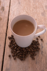 Cup of coffee and coffee bean on wood
